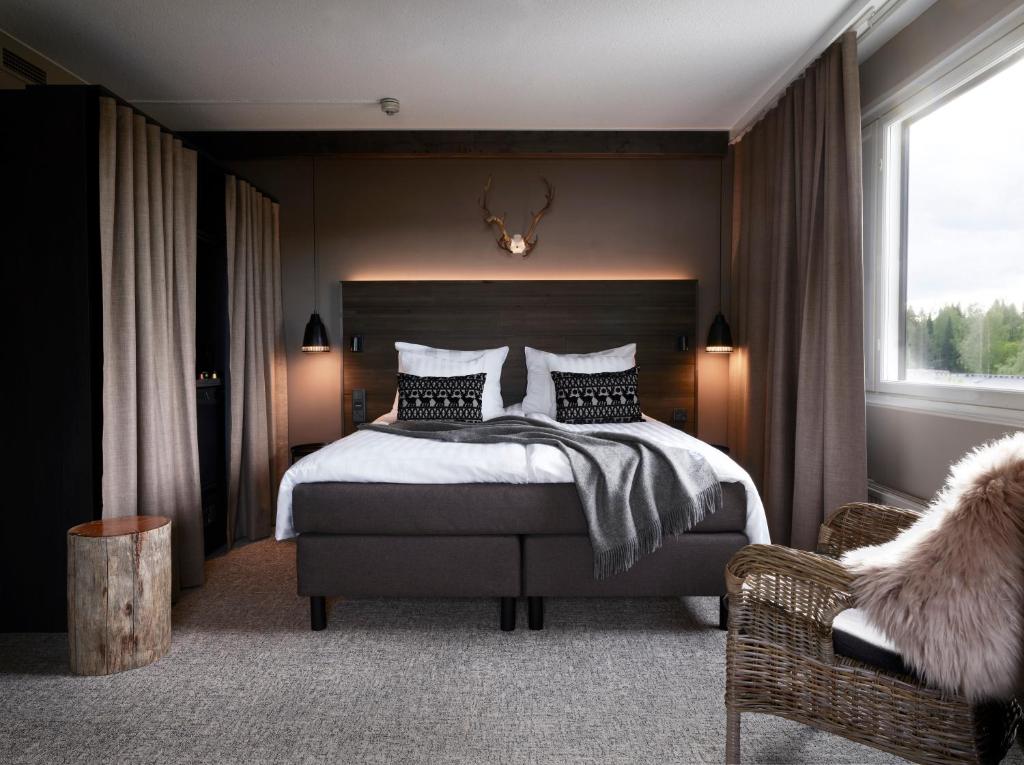 库奥皮奥Lapland Hotels Kuopio的一间卧室配有一张大床和一把椅子