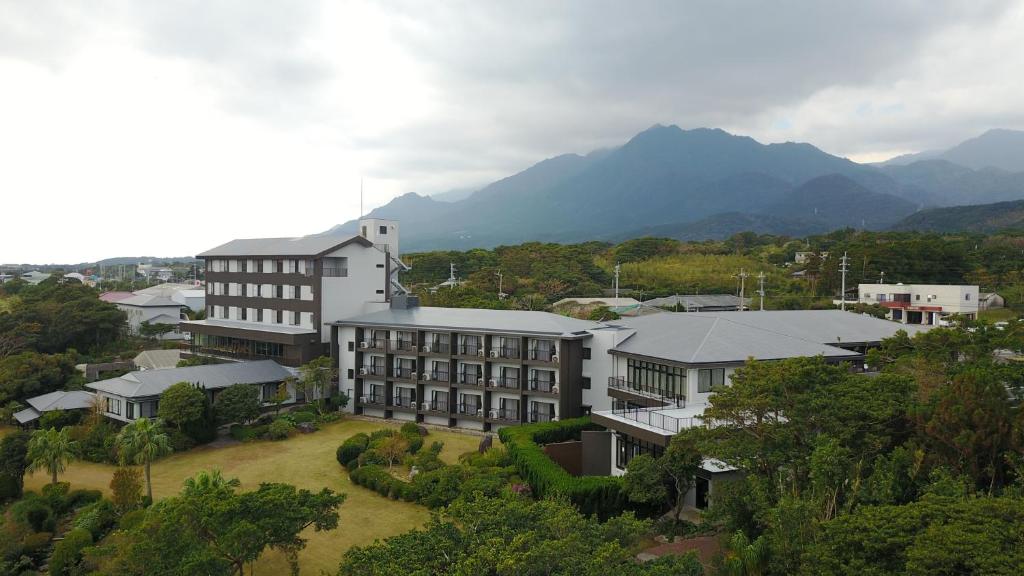 屋久岛屋久岛绿色酒店的享有建筑的空中景观,以群山为背景