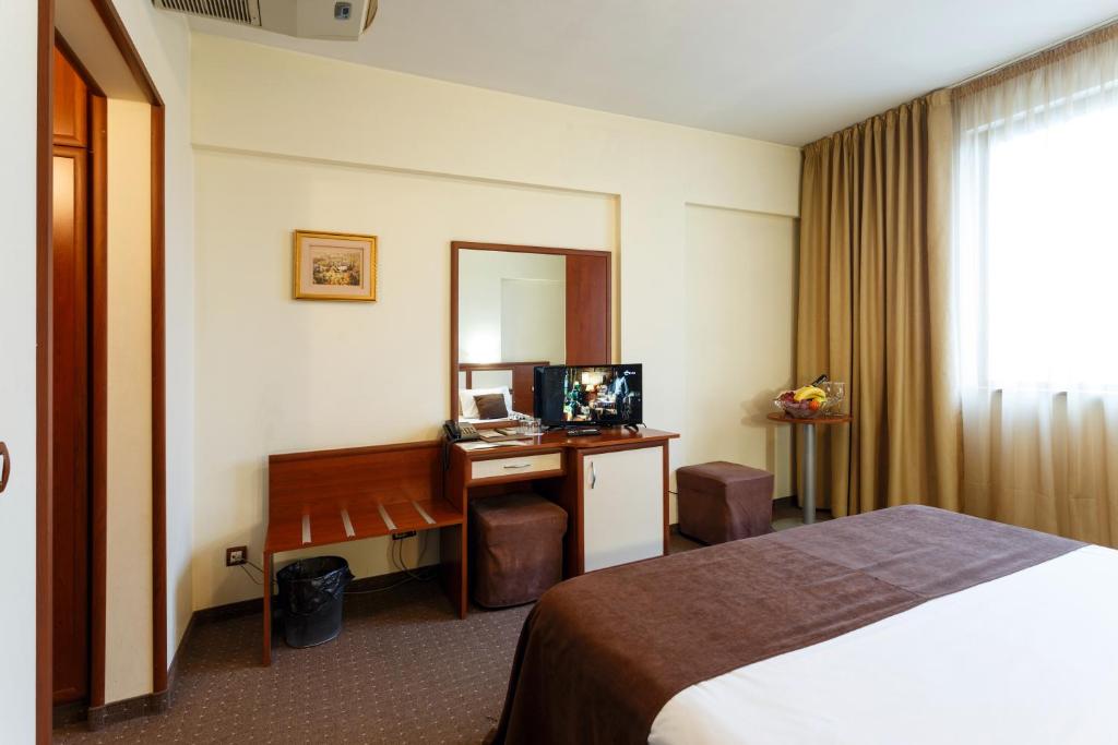 索非亚娜代日达酒店 的酒店客房带一张床、一张书桌和一面镜子