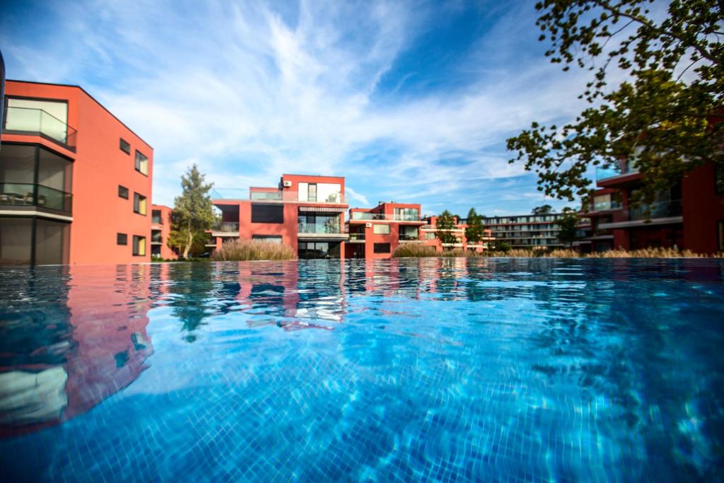 巴拉通雷勒Bavaria Club Apartman的一座大型游泳池,位于部分建筑前