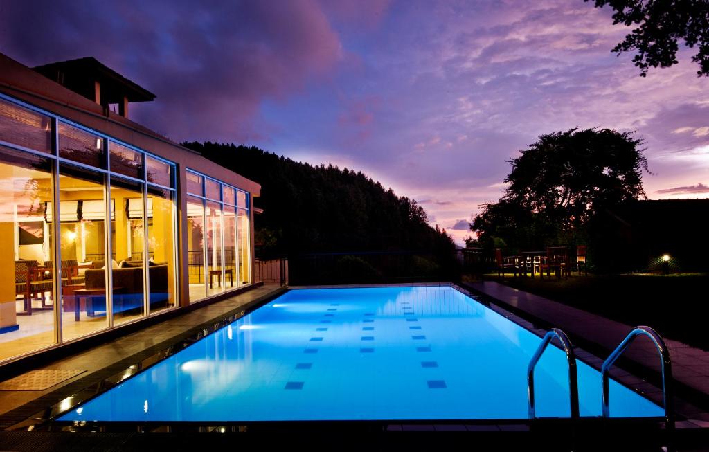 康提Melheim Kandy Villas的夜间在房子前面的游泳池