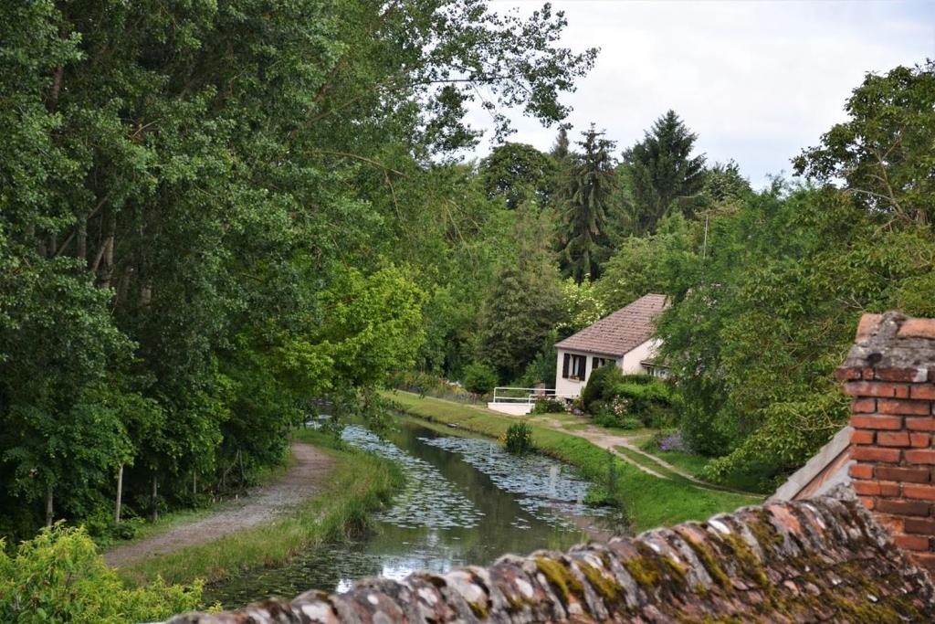 Châtres-sur-Cher谢河畔沙特雷住宿加早餐旅馆的河边的房屋,有砖墙
