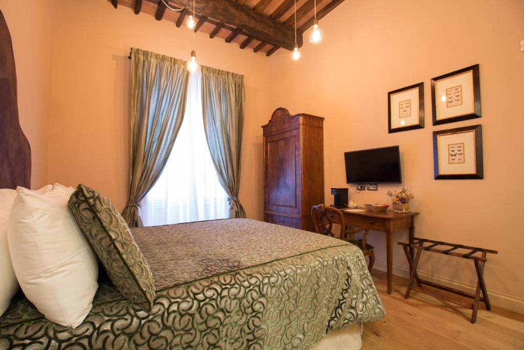 萨尔扎纳Le Camere Di Boccanegra的一间卧室配有一张床、一个窗口和一张书桌