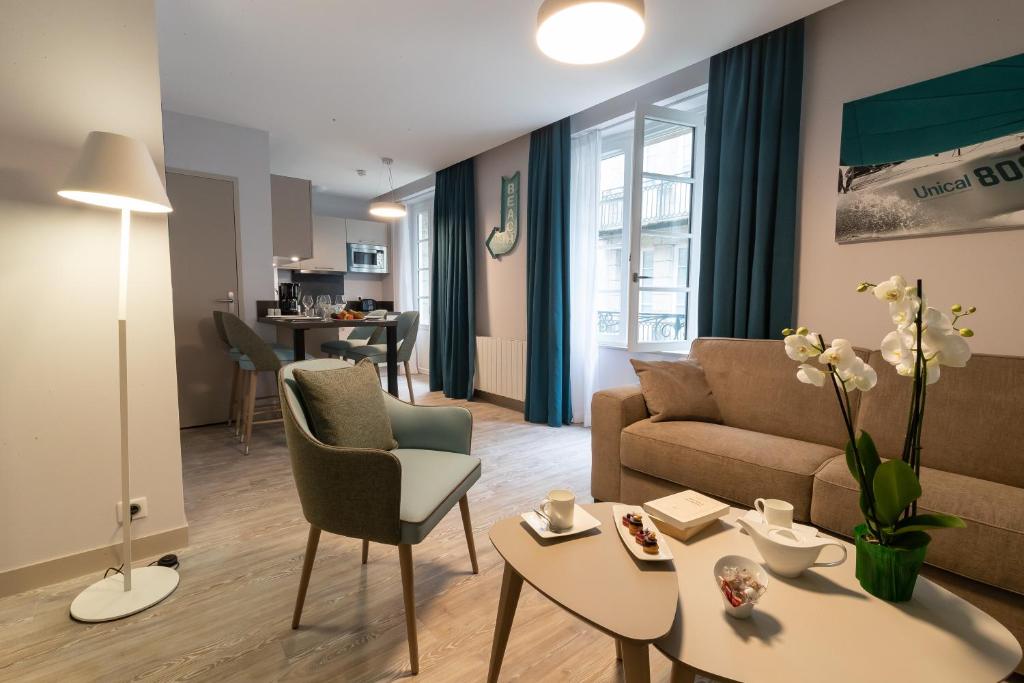 圣马洛Appartements des Marins的客厅配有沙发和桌子