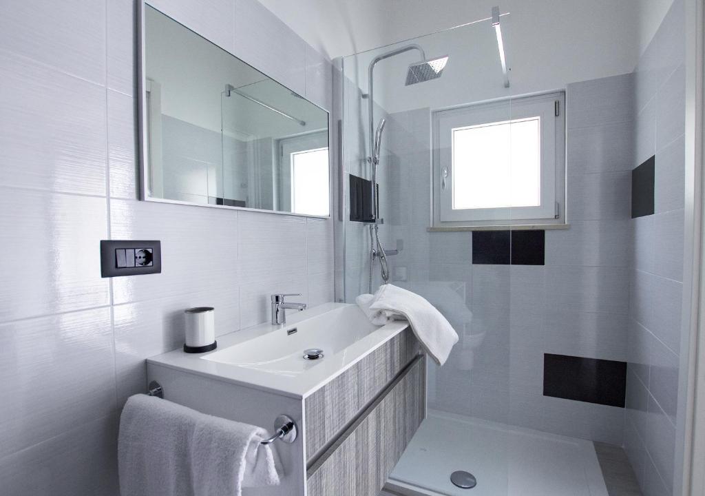 普尔萨诺B&B Alto Salento - Pool and Sun的白色的浴室设有水槽和镜子