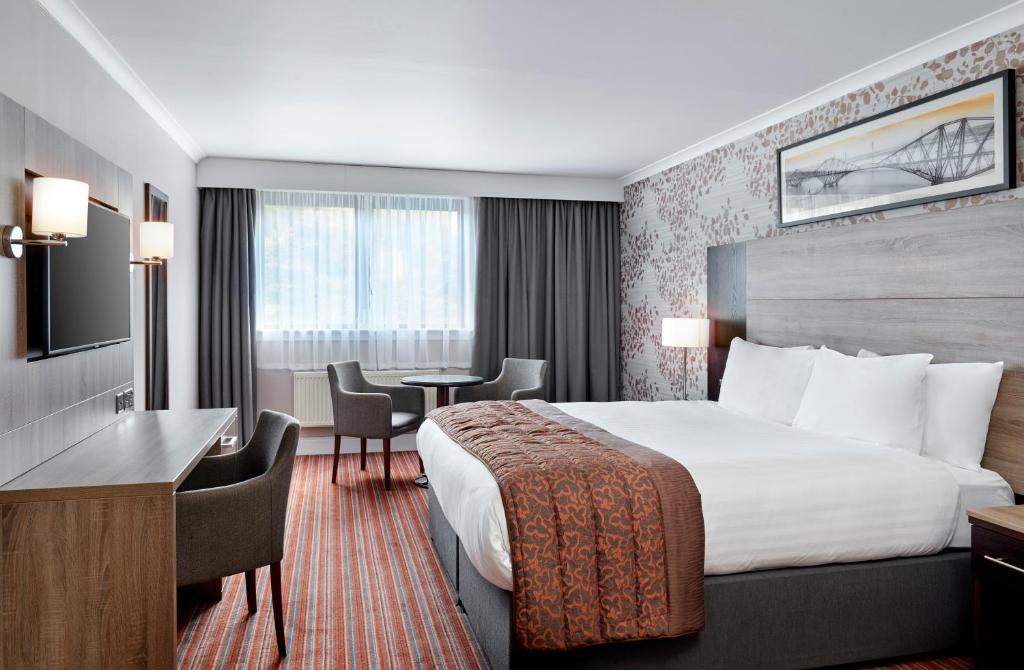 爱丁堡Leonardo Edinburgh Murrayfield的配有一张床和一张书桌的酒店客房