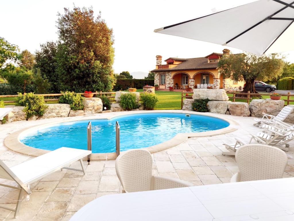卡潘诺里Tuscan Villa exclusive use of private pool A/C Wifi Villa Briciola的一个带椅子和遮阳伞的游泳池