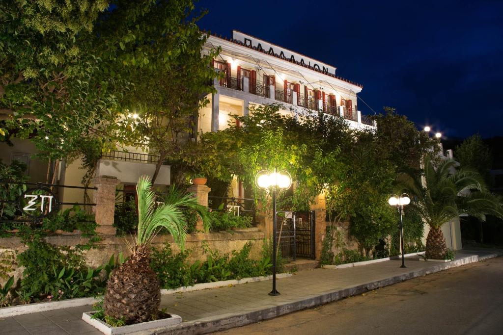 艾迪普索斯Ξενοδοχείο 'ΠΑΛΛΑΔΙΟΝ' Hotel 'PALLADION'的一座晚上在前面有 ⁇ 萝的建筑