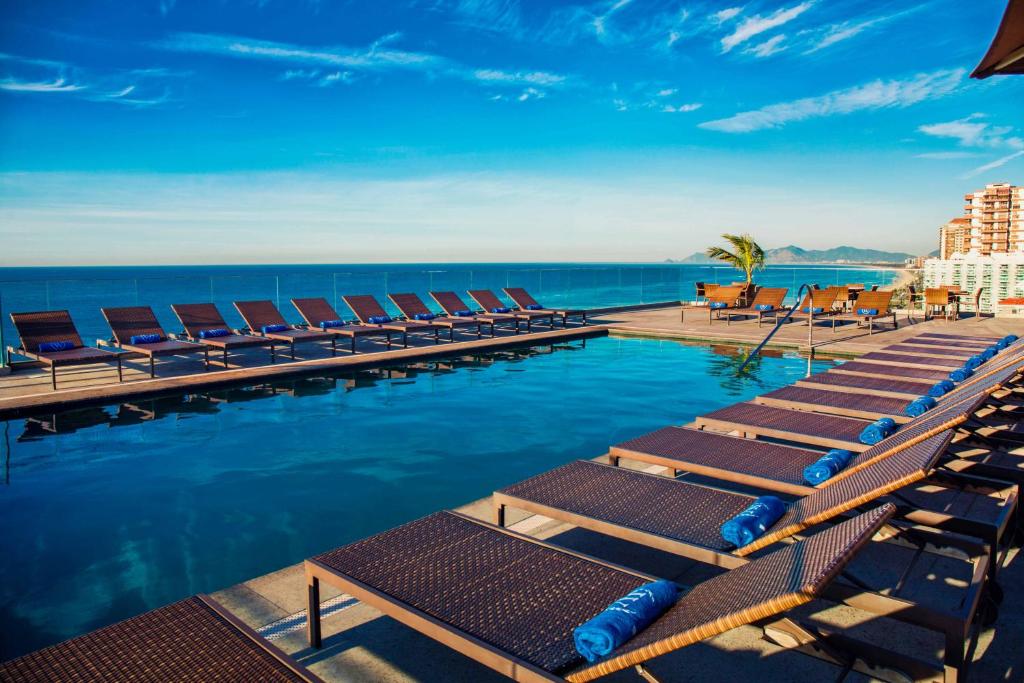 里约热内卢Windsor Oceanico Hotel的一个带躺椅的游泳池和海洋