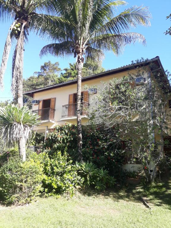 康赛瓦托利亚Pousada da Figueira的前面有棕榈树的房子