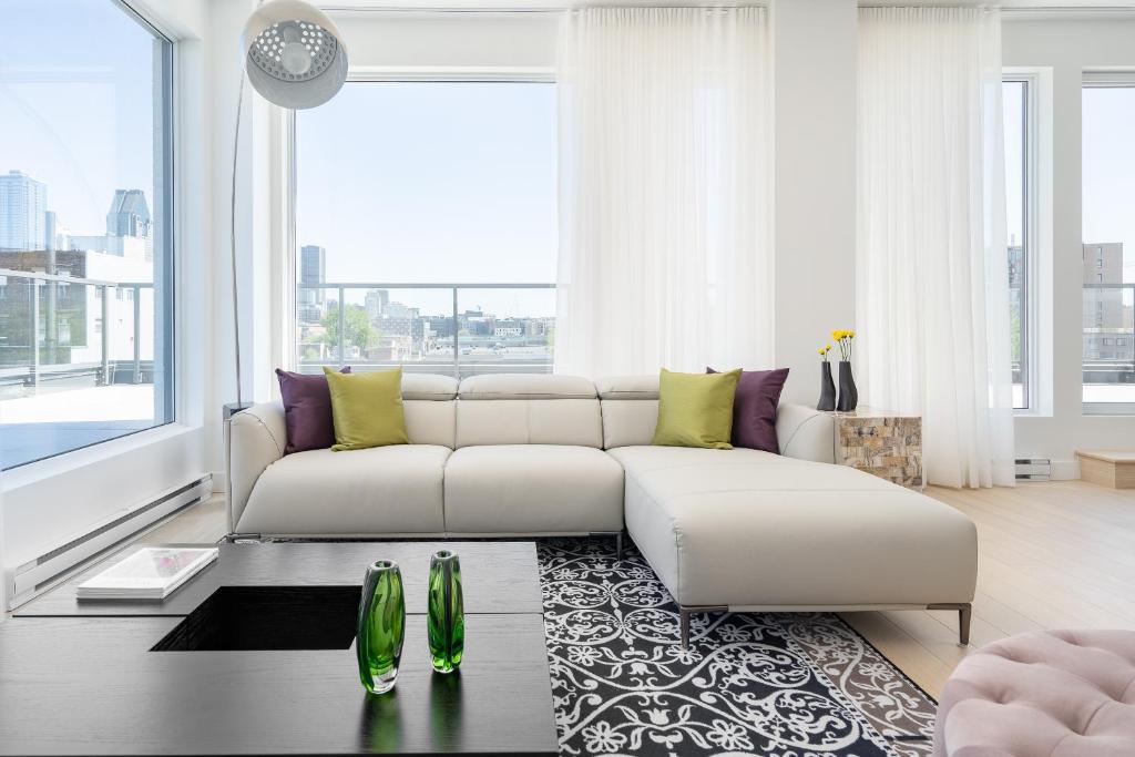 蒙特利尔Le Se7t Penthouses的客厅配有白色沙发和大窗户