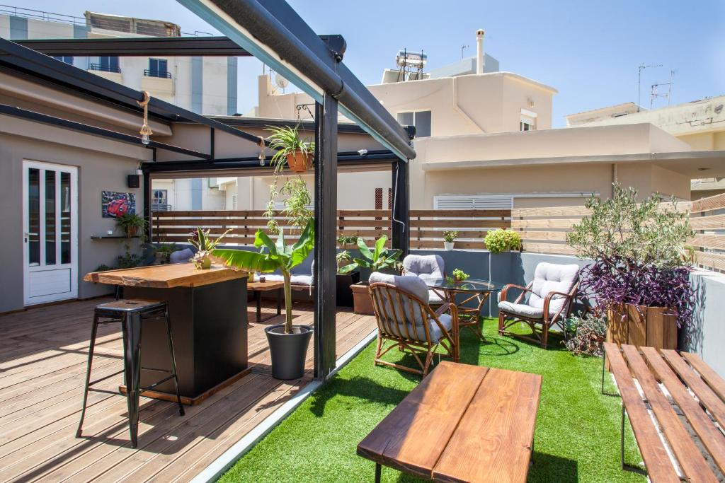海若克利欧So Young Hostel的屋顶庭院设有木桌、椅子和草地。