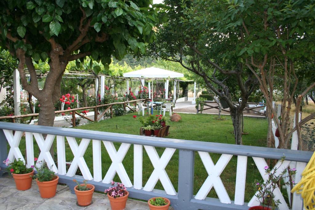 斯塔菲罗斯Alexandra Studios的白色的栅栏,有盆栽植物和树木