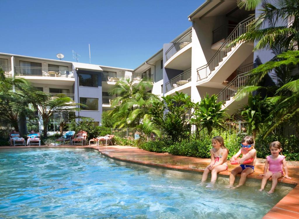麦夸里港弗林斯海滩度假酒店的三个孩子坐在度假村的游泳池里