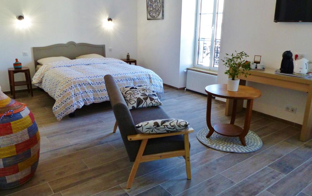 阿旺桥Résidence 14 Moulins的一间卧室配有一张床、一把椅子和一张桌子