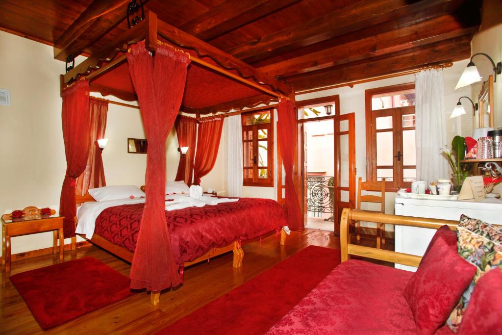 干尼亚帕拉佐迪皮特罗公寓酒店的一间卧室配有一张带红色窗帘的天蓬床