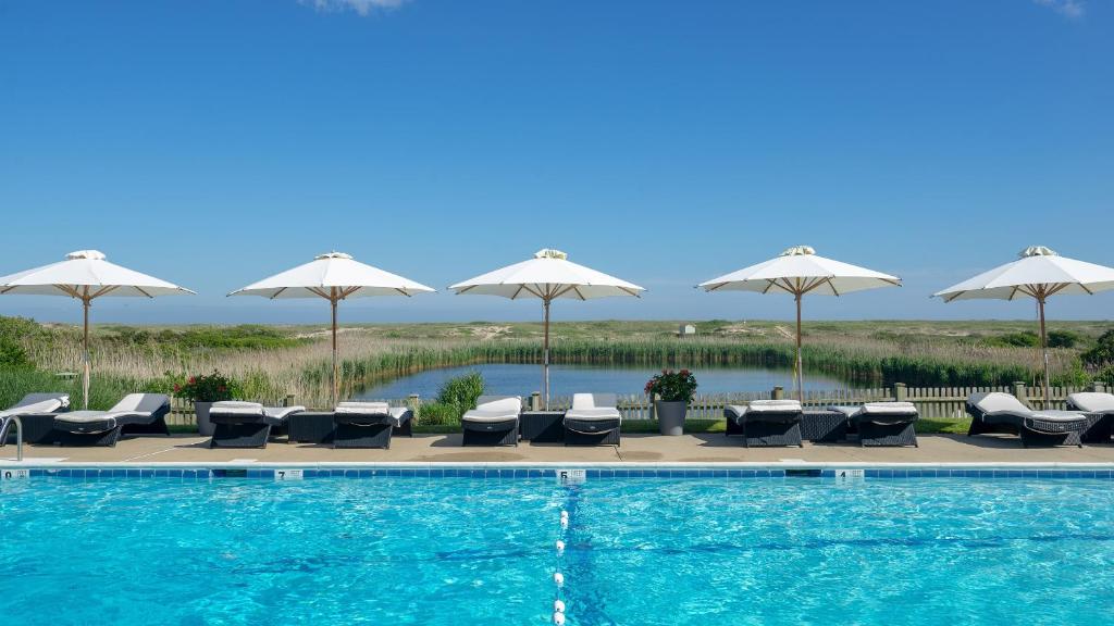 阿默甘西特阿玛甘赛特海洋沙丘公寓的一个带躺椅和遮阳伞的游泳池