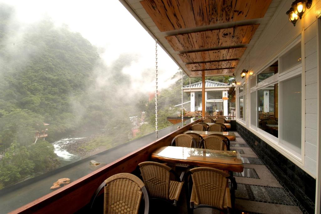 乌来乌来明月温泉会馆的一间带桌椅并享有河景的餐厅