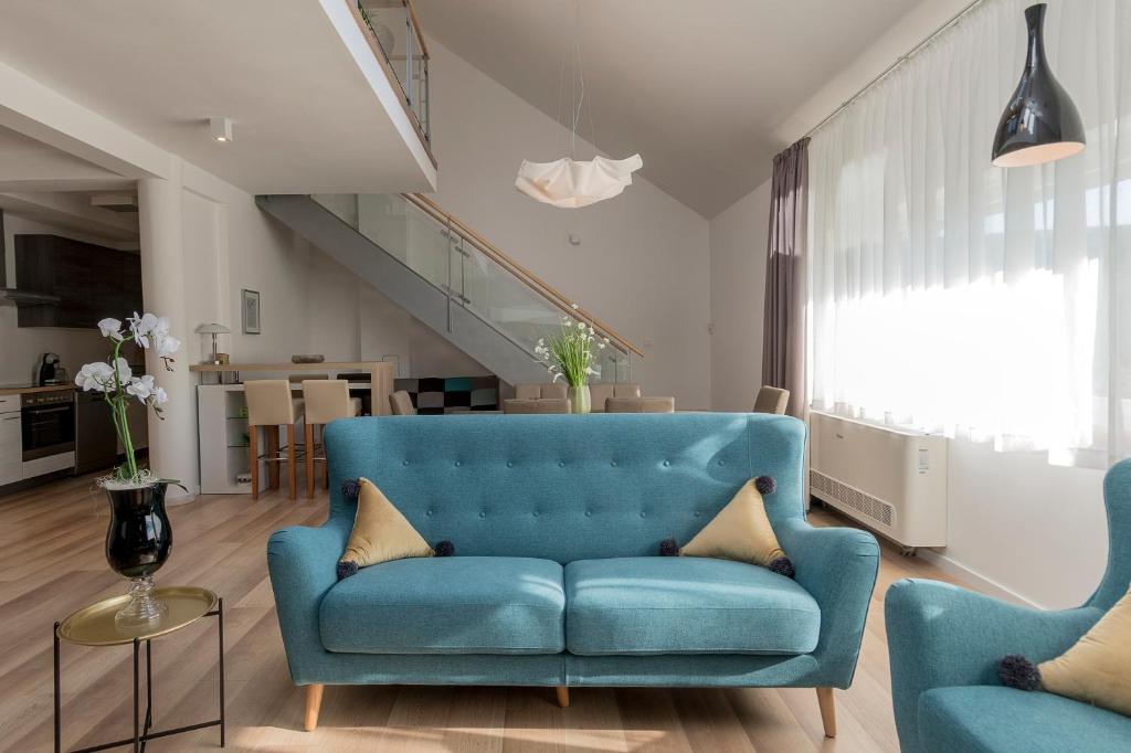 查科韦茨Millennium apartments的客厅配有蓝色的沙发和两把椅子