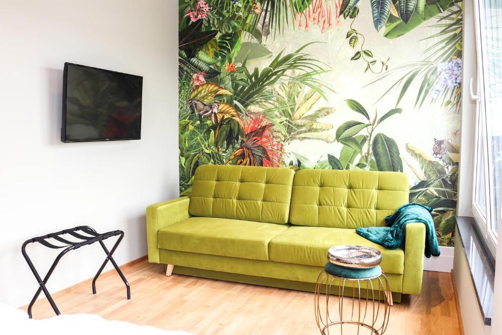 巴特沃里斯霍芬Das Fischer Boardinghouse BW的客厅配有绿色沙发和壁画