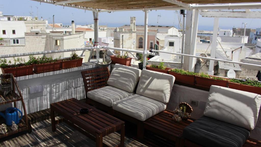 莫诺波利B&B Casa Cimino - Monopoli - Puglia的阳台配有两把椅子和一张屋顶沙发。