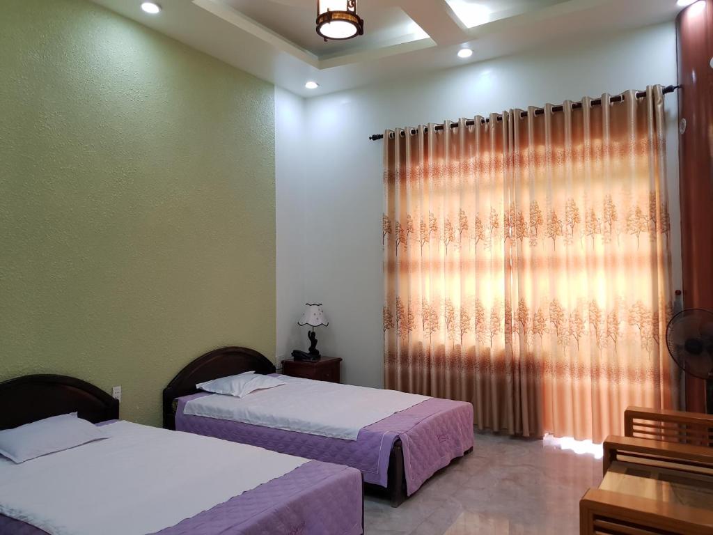 Phủ LýKhách sạn Anh Đào的一间卧室设有两张床和窗户。