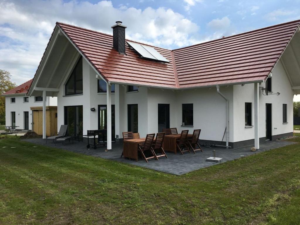 特伦特Villa Mondlicht的白色的房子,有红色的屋顶和椅子
