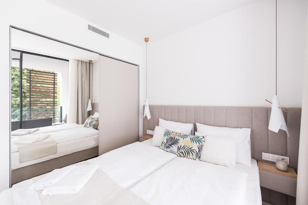 蒂豪尼OliverLux Aparthotel的卧室配有一张白色大床和镜子