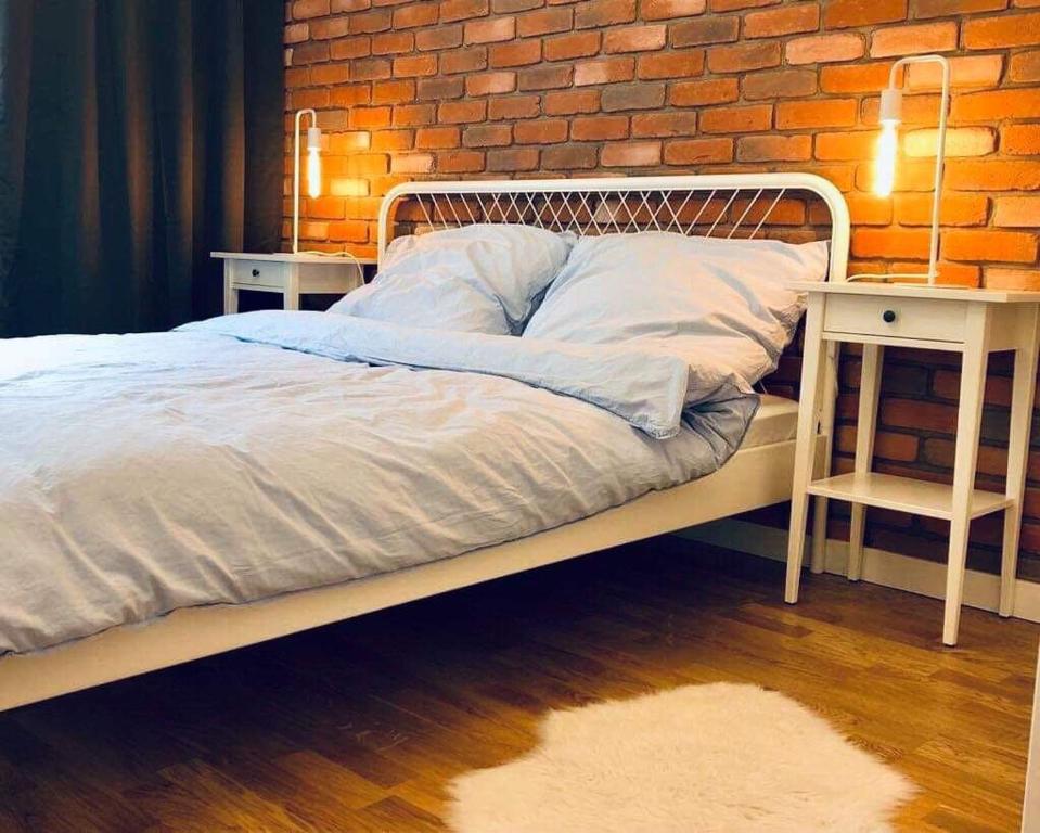 格但斯克Lofty & Apartamenty Garnizon Gdańsk的一间卧室设有一张床和砖墙