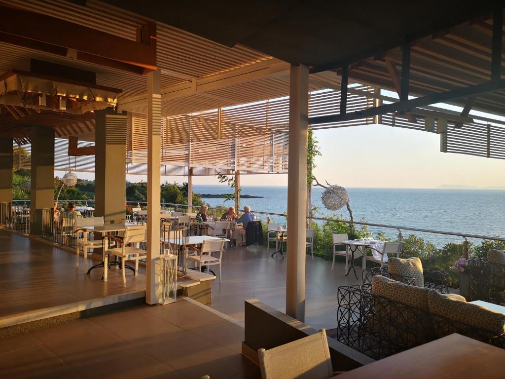 斯卡费迪亚爱奥尼亚马雷代套房度假酒店的一间带桌椅的海景餐厅