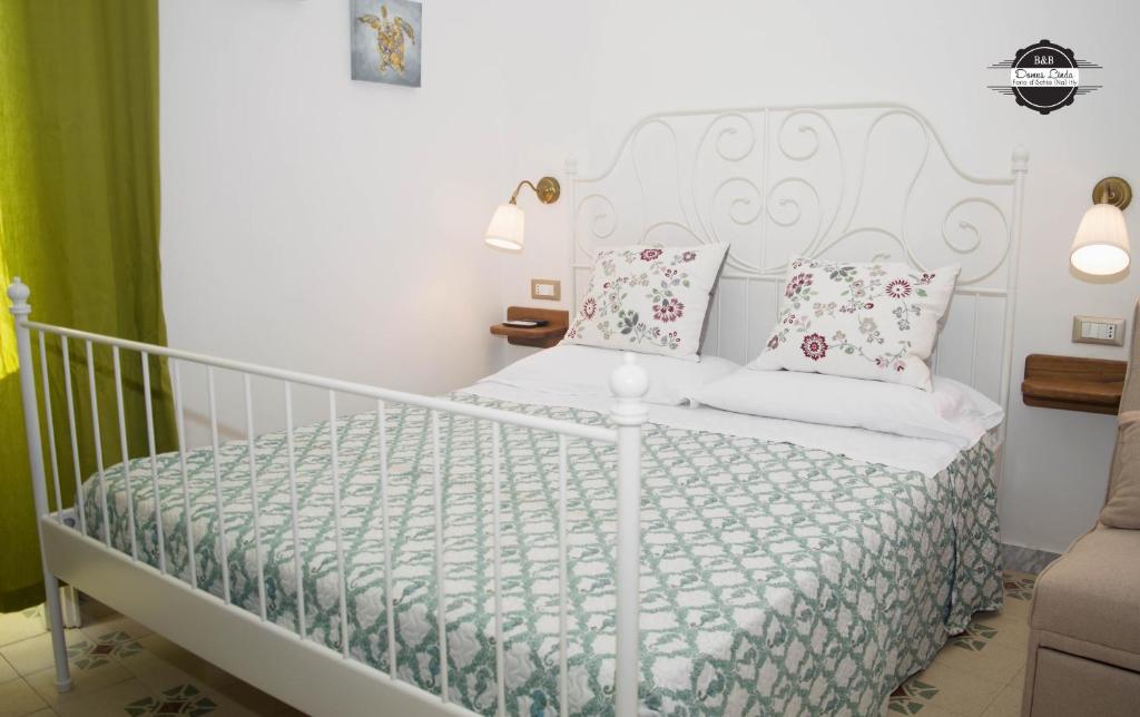 伊斯基亚Domus Linda B&B的卧室配有白色床和粉红色枕头
