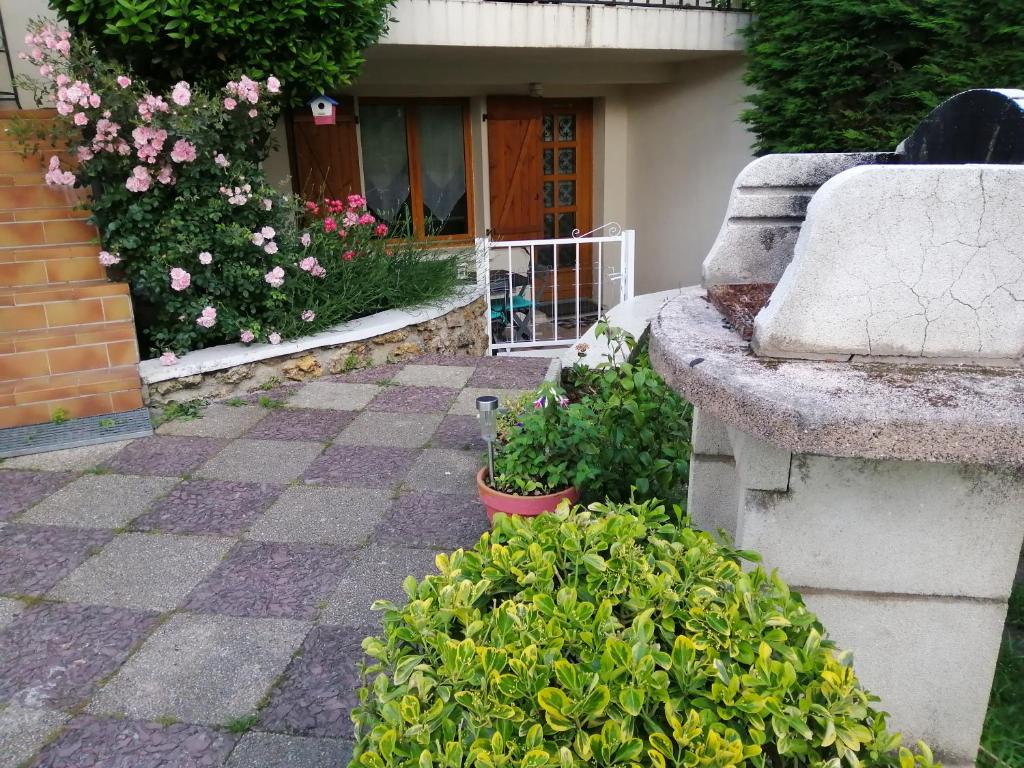 昂迪伊appartement type f2 proche PARIS 25 KM的一座种有粉红色花卉和石头长凳的花园