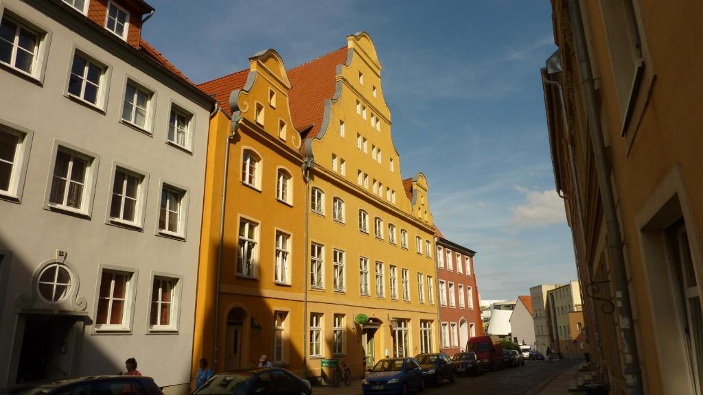 施特拉尔松德Altstadt Pension Hafenblick的街道上一排有汽车的建筑
