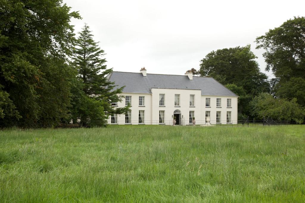 BallyraggetGrange Manor的一座大白色房子,有一片大片的草地