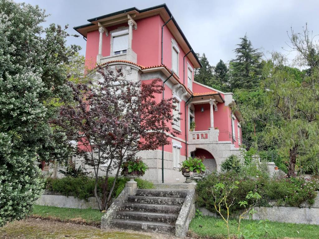 吉马良斯埃斯皮霍萨住宿加早餐旅馆的前面有楼梯的红色房子