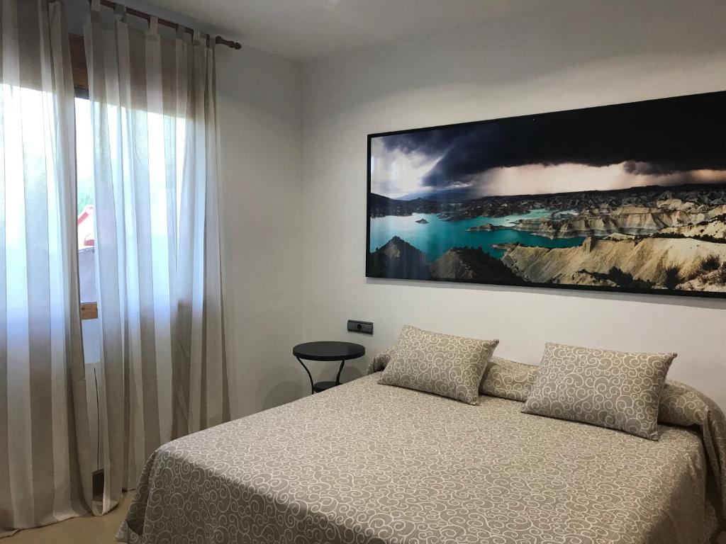 阿尔阿马德穆尔西亚Apartamento Sierra Espuña的卧室配有一张床,墙上挂着一幅大画