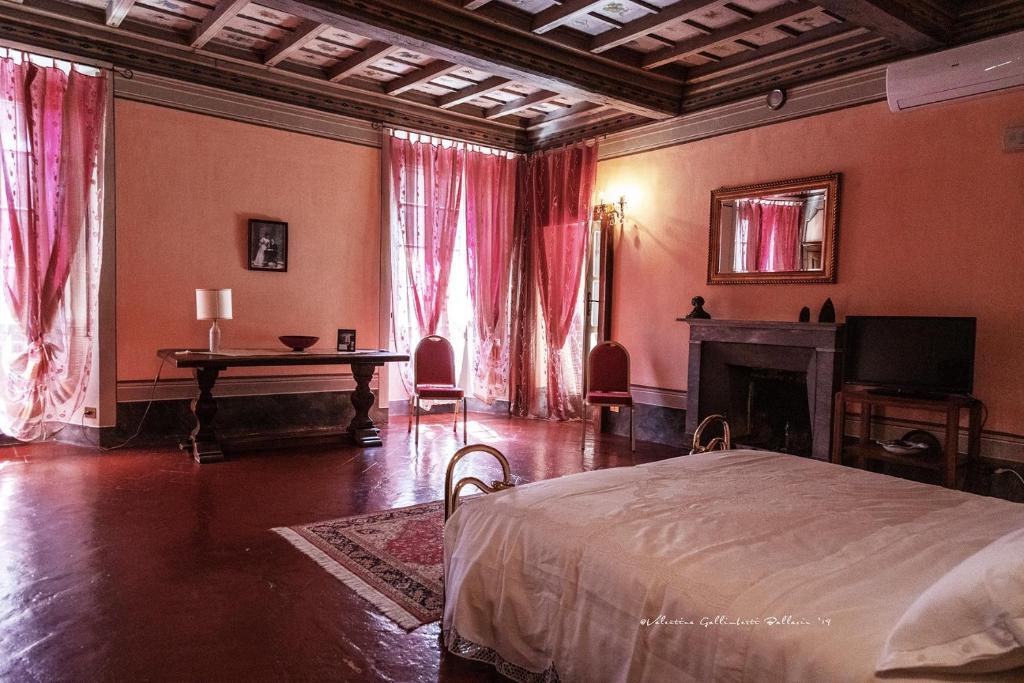 格罗佩洛凯罗利坎托尼旅馆的一间卧室配有一张床、一张桌子和一个壁炉