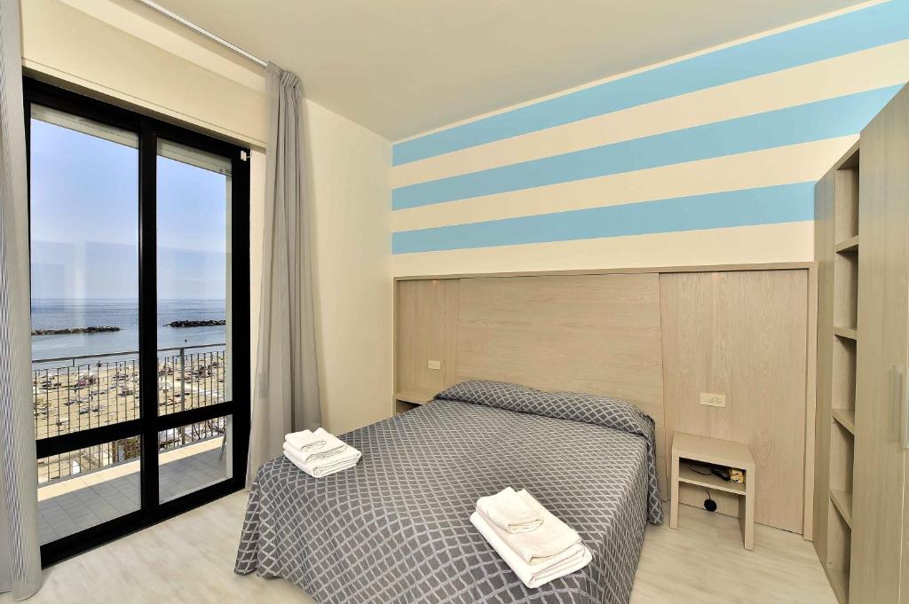 贝拉里亚-伊贾马里纳Hotel Admiral的一间卧室设有一张床和一个大窗户