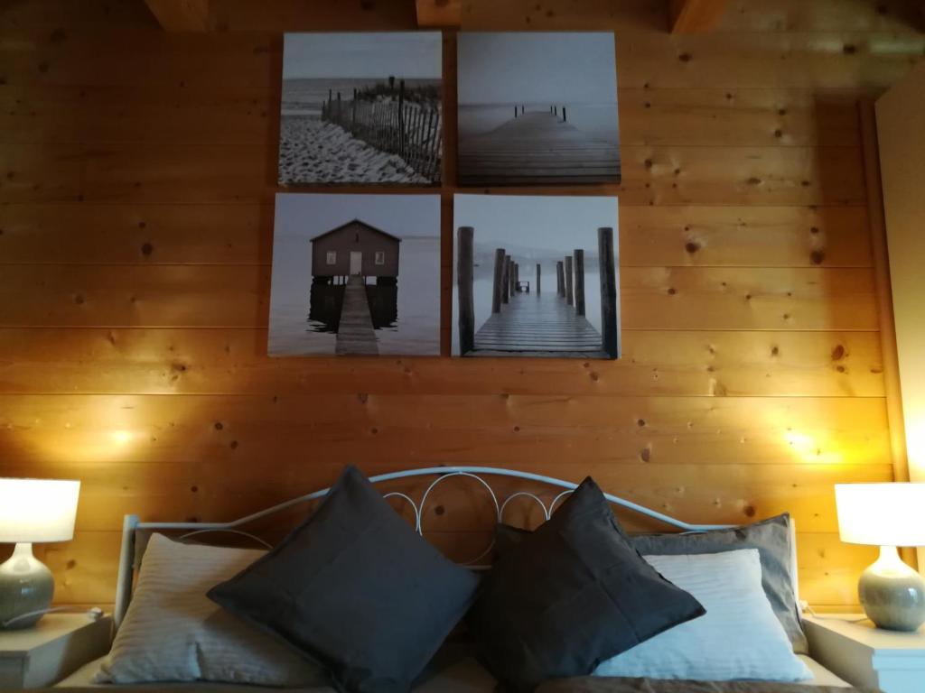 基姆湖畔贝尔瑙Studio im Blockhaus am Chiemsee的一间设有木墙的客房,沙发上方有图片