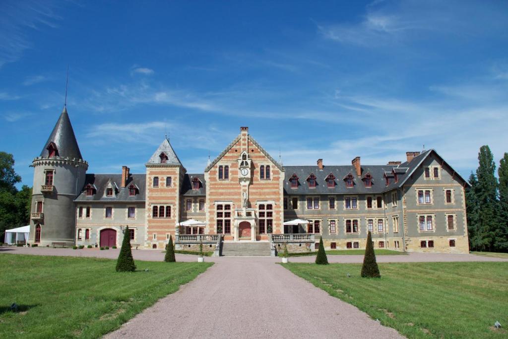 Lurcy-LévisChâteau de Béguin的一座大城堡,前面有草地