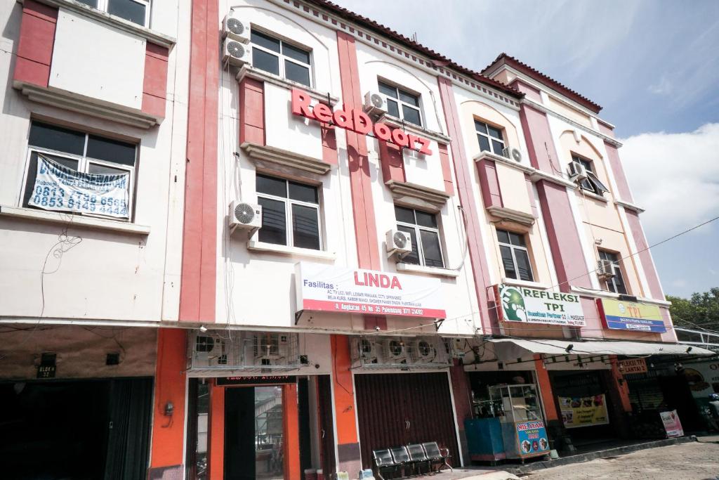 巨港RedDoorz near Palembang Square Mall 2的粉红色和白色的建筑,上面有标志