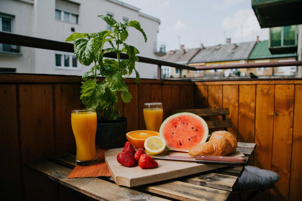 布达佩斯布达中心公寓的阳台上的桌子上摆放着水果和饮料