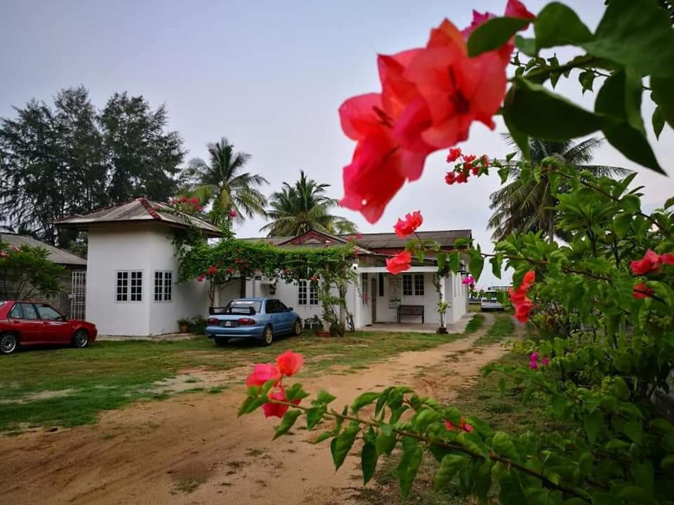 巴佐ALA Beach Lodge - Markisa Homestay的前面有红花的房子