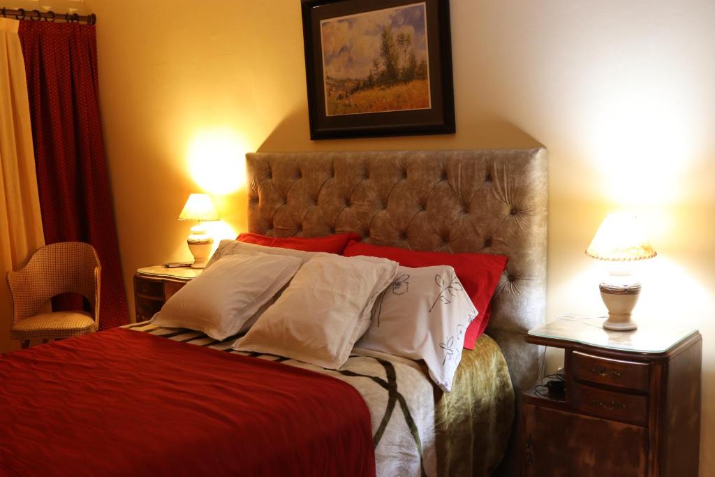 科尔多瓦Casa Alberdi的一间卧室配有红色床单和白色枕头。