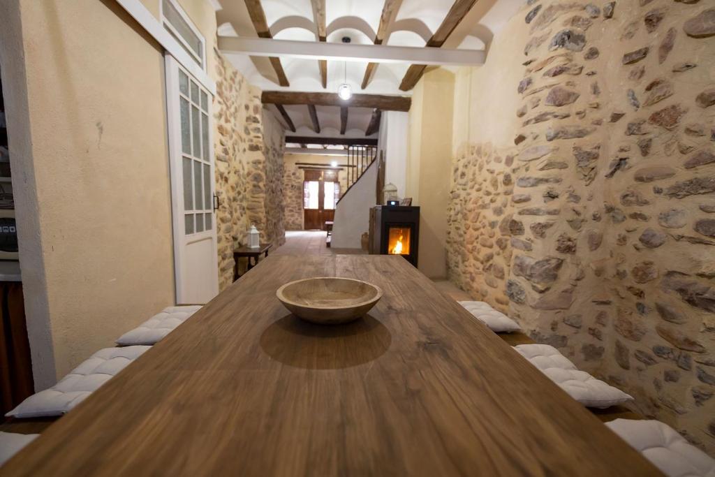 蒙塔尼约斯Casa Rural Pradas的石墙客房内的大木桌
