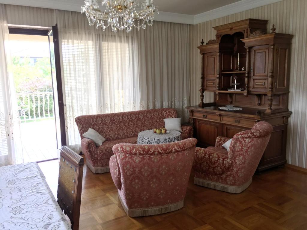 巴登Zeitreise-Ferienhaus的客厅配有沙发、椅子和吊灯
