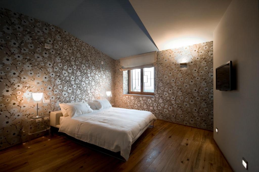 莫罗达尔巴Le Civette的卧室配有一张白色大床和一堵墙