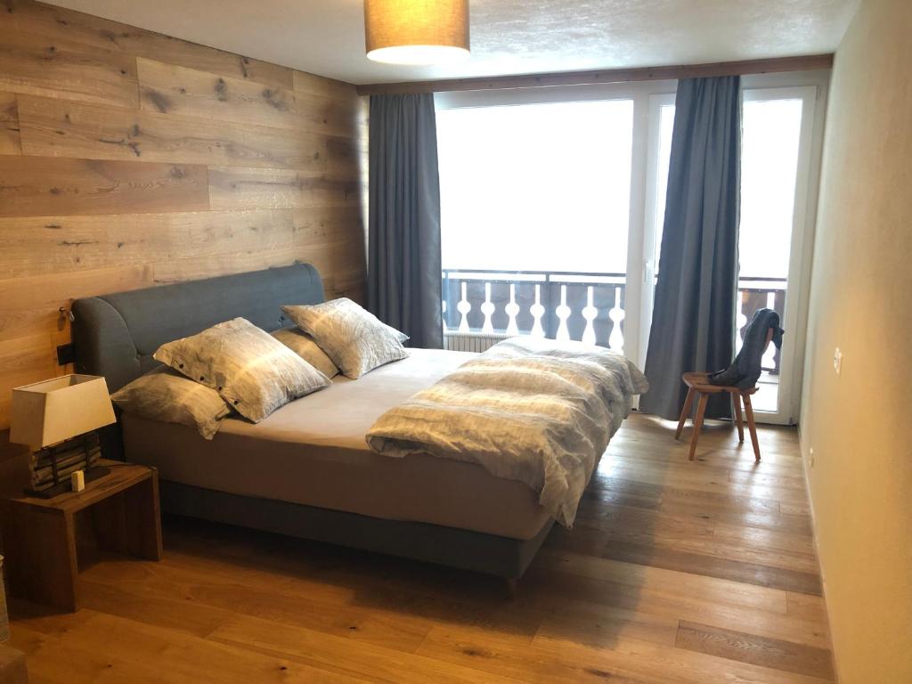 Laax-MurschetgLaax Flims Luxury Large apartment near Rock Resort的一间卧室配有一张木墙床