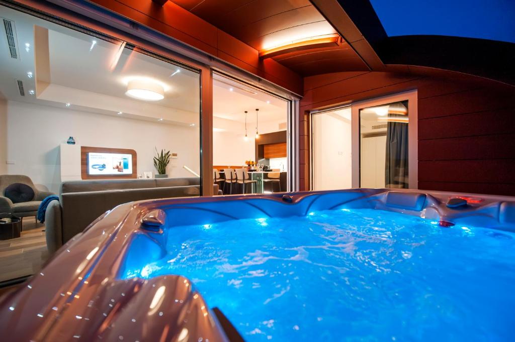 罗维尼The Q - Superior Apartment的客厅里的大型蓝色热水浴缸