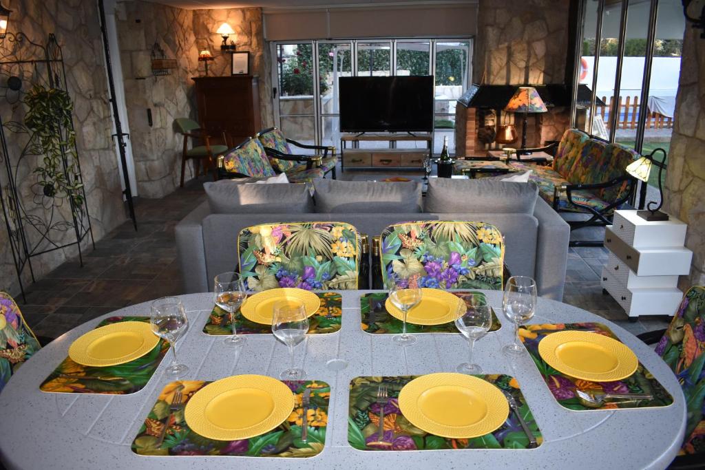 塔拉戈纳VILLA GARDEN的一张白色的桌子,上面有黄色的板子和玻璃杯